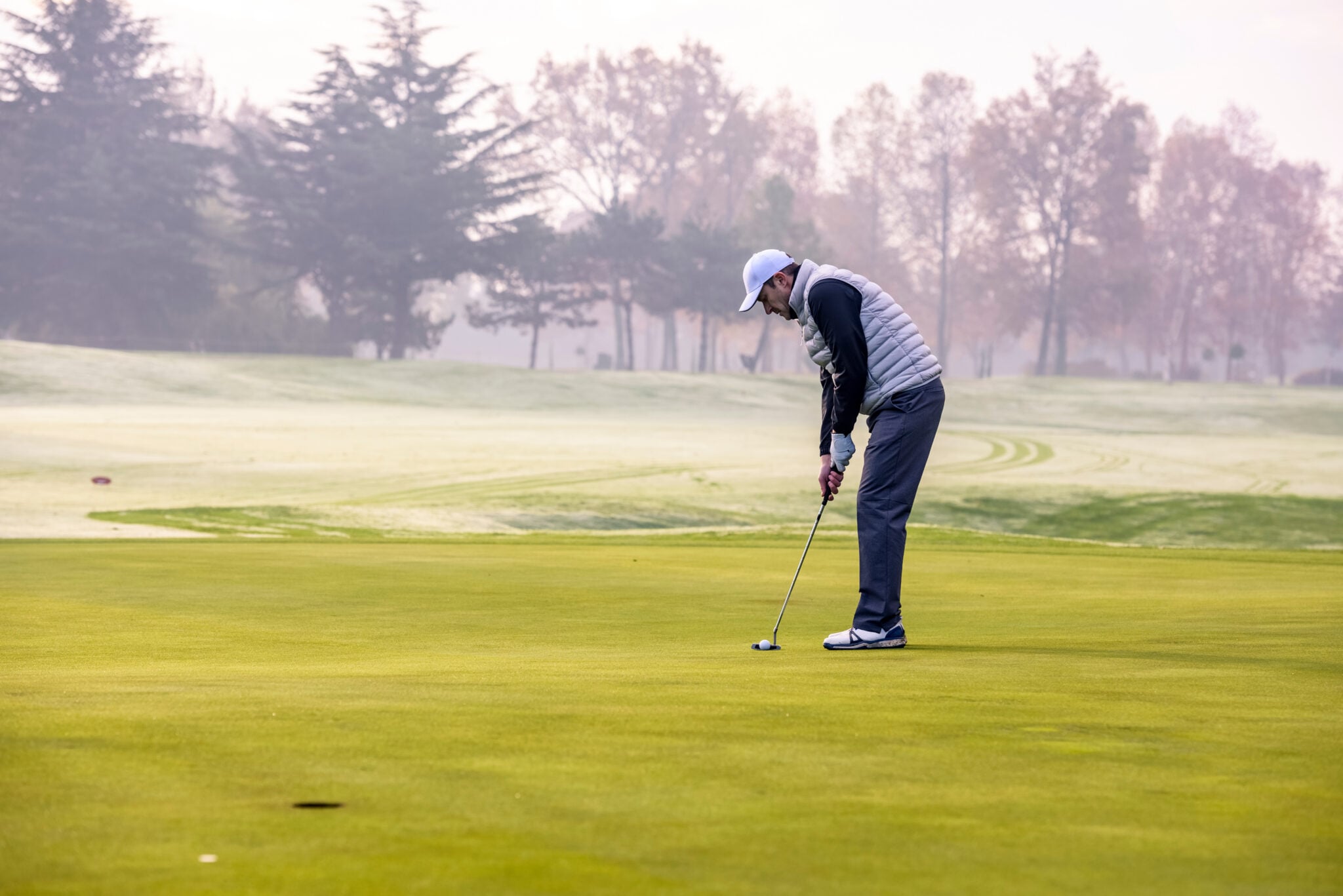 A player hits a putt amid the backdrop of icy conditions on the course | Source: Adobe Stock